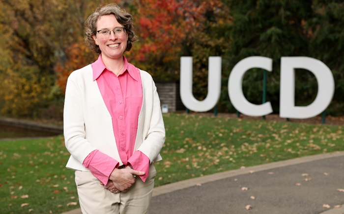 A portrait photo of Conway Fellow Niamh Nowlan standing in front of a UCD sign
